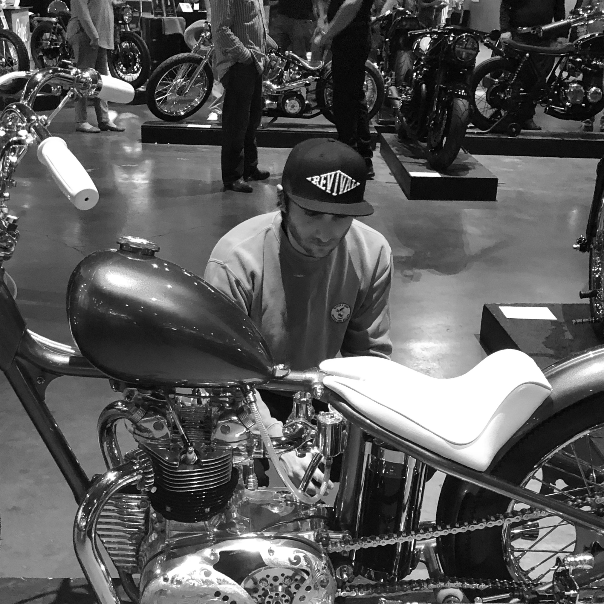 Kyle Parsons at The One Motorcycle Show, inspecting a custom bike.